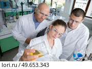 pensive chemist selects an essential substance for the experiment. Стоковое фото, агентство Ingram Publishing / Фотобанк Лори