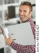 middle aged man holding an open folder. Стоковое фото, агентство Ingram Publishing / Фотобанк Лори
