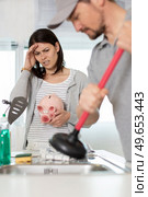 cleaning clogged pipes in the kitchen sink with a plunger. Стоковое фото, агентство Ingram Publishing / Фотобанк Лори