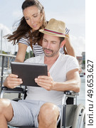 man on wheelchair with tablet in hands outdoors. Стоковое фото, агентство Ingram Publishing / Фотобанк Лори
