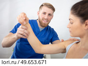 handsome physiotherapist treating patients shoulder. Стоковое фото, агентство Ingram Publishing / Фотобанк Лори