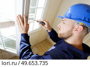young male contractor using screwdriver on window catch. Стоковое фото, агентство Ingram Publishing / Фотобанк Лори