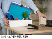 man in office collecting items in a box. Стоковое фото, агентство Ingram Publishing / Фотобанк Лори