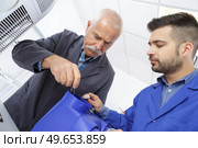 electrician with apprentice working in new home. Стоковое фото, агентство Ingram Publishing / Фотобанк Лори