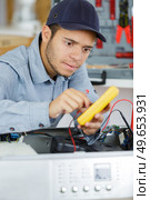 electrician is repairing a clothes washer with gripper. Стоковое фото, агентство Ingram Publishing / Фотобанк Лори