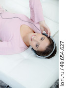 woman with headphones lying down. Стоковое фото, агентство Ingram Publishing / Фотобанк Лори