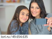 cute child and mother make selfie on mobile phone. Стоковое фото, агентство Ingram Publishing / Фотобанк Лори