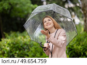 woman rainy girl with transparent umbrella holds out her hand. Стоковое фото, агентство Ingram Publishing / Фотобанк Лори