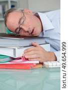 over-worked tired businessman at office sleeping at his desk. Стоковое фото, агентство Ingram Publishing / Фотобанк Лори