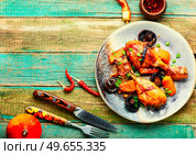Chicken drumsticks baked with pumpkin on the plate. Copy space. Chicken thighs roasted with pumpkin, space for text. Стоковое фото, агентство Ingram Publishing / Фотобанк Лори