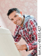 a man is fixing radiator. Стоковое фото, агентство Ingram Publishing / Фотобанк Лори