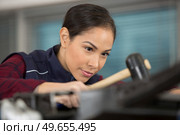serious female car painter working in workshop. Стоковое фото, агентство Ingram Publishing / Фотобанк Лори
