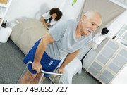 nurse assisting an elderly man with a walking frame. Стоковое фото, агентство Ingram Publishing / Фотобанк Лори