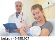 doctor and smiling woman holding baby. Стоковое фото, агентство Ingram Publishing / Фотобанк Лори