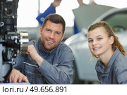 portrait of mechanic with female apprentice. Стоковое фото, агентство Ingram Publishing / Фотобанк Лори
