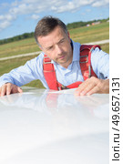 portrait of a man inspecting glider. Стоковое фото, агентство Ingram Publishing / Фотобанк Лори