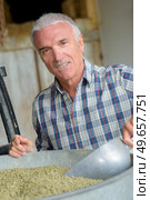 portrait of a farmer scooping dry product. Стоковое фото, агентство Ingram Publishing / Фотобанк Лори