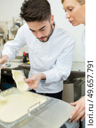 portrait of workers putting chocolate in mold. Стоковое фото, агентство Ingram Publishing / Фотобанк Лори