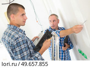 builder applies glue on a wall for a ceramic tile. Стоковое фото, агентство Ingram Publishing / Фотобанк Лори
