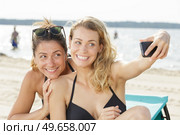 two women do selfie on vacation on the beach. Стоковое фото, агентство Ingram Publishing / Фотобанк Лори