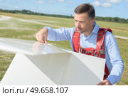 portrait of a man checking scratches on the wings. Стоковое фото, агентство Ingram Publishing / Фотобанк Лори