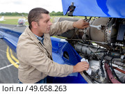 aircraft engineer dismantling jet plane outdoors. Стоковое фото, агентство Ingram Publishing / Фотобанк Лори