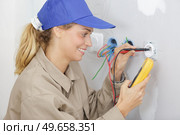 portrait of a woman measuring electrical current. Стоковое фото, агентство Ingram Publishing / Фотобанк Лори