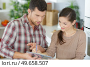 casual couple checking things to do on clipboard. Стоковое фото, агентство Ingram Publishing / Фотобанк Лори