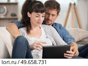 couple using a tablet computer in their living room. Стоковое фото, агентство Ingram Publishing / Фотобанк Лори