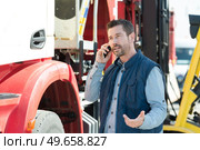 lorry driver making questioning gesture while talking on telephone. Стоковое фото, агентство Ingram Publishing / Фотобанк Лори
