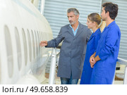 Man showing aircraft fuselage to students. Стоковое фото, агентство Ingram Publishing / Фотобанк Лори