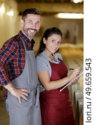 couple in wine cellar writing information on clipboard. Стоковое фото, агентство Ingram Publishing / Фотобанк Лори