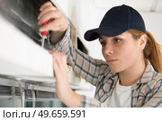 female contractor adjusting a window blind. Стоковое фото, агентство Ingram Publishing / Фотобанк Лори