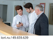 male trainee receptionists in receptionist class. Стоковое фото, агентство Ingram Publishing / Фотобанк Лори