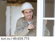 portrait of glazier using screwdriver on pvc windows. Стоковое фото, агентство Ingram Publishing / Фотобанк Лори