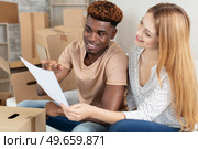 couple surrounded by cardboard boxes looking at paperwork. Стоковое фото, агентство Ingram Publishing / Фотобанк Лори