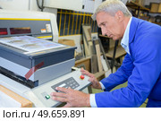 Man setting up photocopying machine. Стоковое фото, агентство Ingram Publishing / Фотобанк Лори