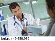doctor passing box of tissues to patient. Стоковое фото, агентство Ingram Publishing / Фотобанк Лори