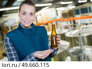 female brewer holding barley grain and beer in brewery factorys. Стоковое фото, агентство Ingram Publishing / Фотобанк Лори