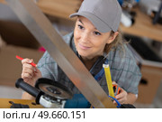 female carpenter using electric sander for wood. Стоковое фото, агентство Ingram Publishing / Фотобанк Лори