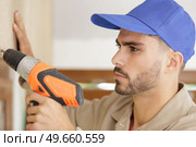 man drilling the wall with drill perforator. Стоковое фото, агентство Ingram Publishing / Фотобанк Лори