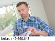 man choosing paint color and pent paper. Стоковое фото, агентство Ingram Publishing / Фотобанк Лори