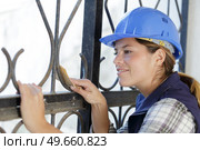 female builder using sandpaper to prepare metal. Стоковое фото, агентство Ingram Publishing / Фотобанк Лори