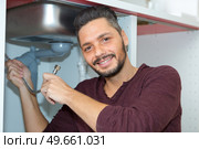 worker with gripper in had is fixing a pipe. Стоковое фото, агентство Ingram Publishing / Фотобанк Лори