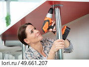 woman using hand drill to assemble a wooden table. Стоковое фото, агентство Ingram Publishing / Фотобанк Лори