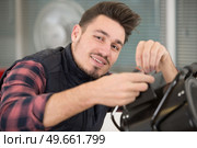 young handsome man working with a professional studio flash. Стоковое фото, агентство Ingram Publishing / Фотобанк Лори
