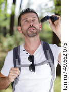 traveler man looks through a binoculars. Стоковое фото, агентство Ingram Publishing / Фотобанк Лори