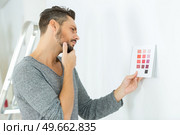man considering colour scheme for wall. Стоковое фото, агентство Ingram Publishing / Фотобанк Лори