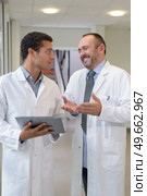 medic laughing at colleagues tablet. Стоковое фото, агентство Ingram Publishing / Фотобанк Лори