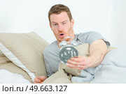 young sleepy man with alarm clock. Стоковое фото, агентство Ingram Publishing / Фотобанк Лори